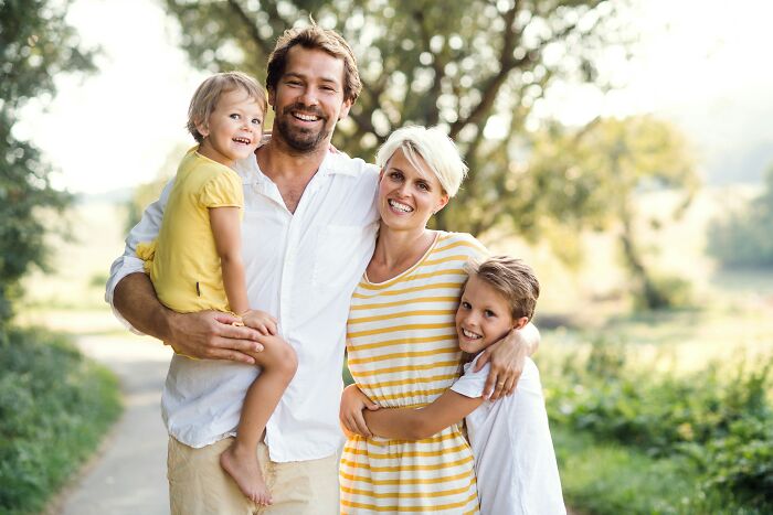 A happy family of four outdoors, a contrast to the unhinged midlife crisis experiences.