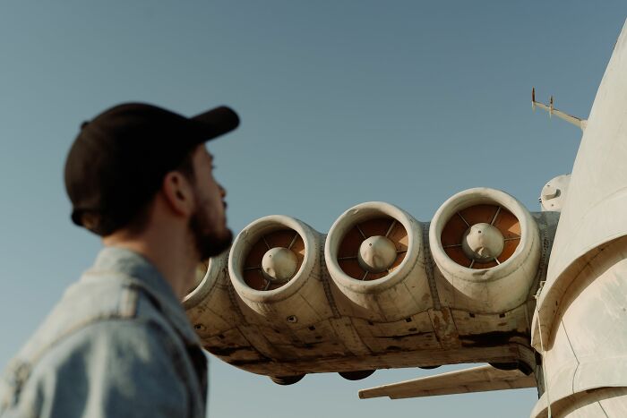 A man looking at large plane engines, representing a midlife crisis or new ventures.