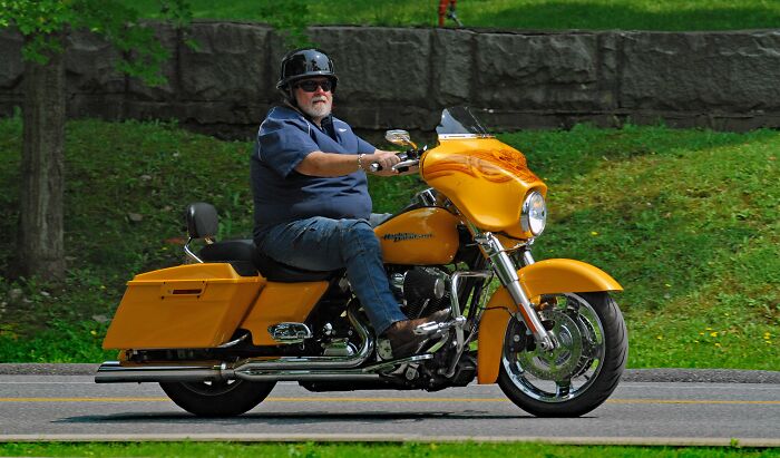 A man riding a motorcycle, showcasing a midlife crisis with a new hobby.