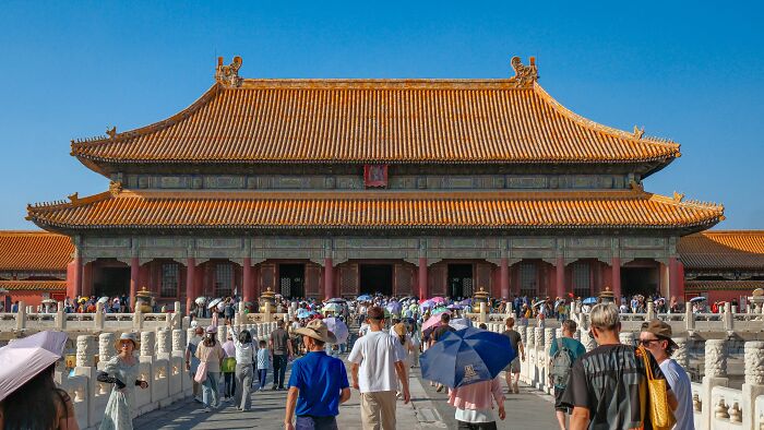 A majestic historic building with many tourists, illustrating a midlife crisis adventure.