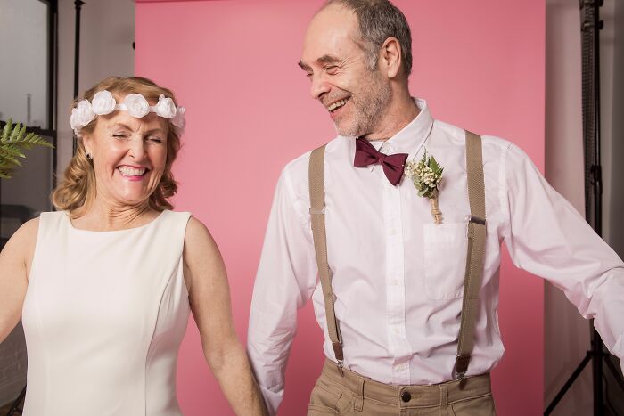 A happy older couple, smiling and holding hands, representing a midlife crisis transformation.