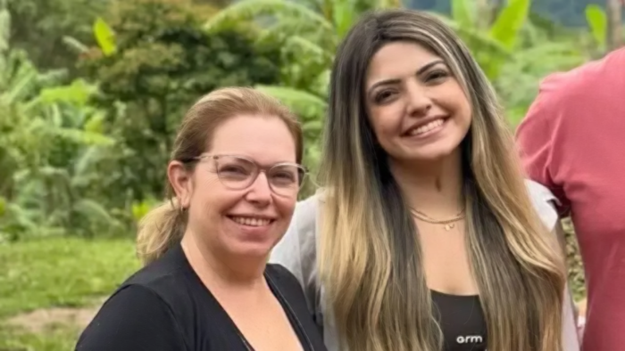 A happy mother and daughter smiling together, representing a close family bond.