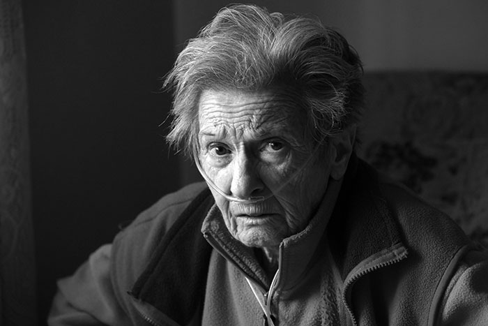 Black and white photo of an elderly woman with an oxygen tube, representing a toxic mom's neglected health for a kidney.