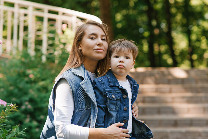 A mother embracing her young son outdoors, representing childhood beliefs.