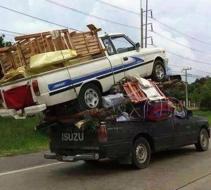Two pickup trucks stacked with furniture and items in a moving fails pics scene