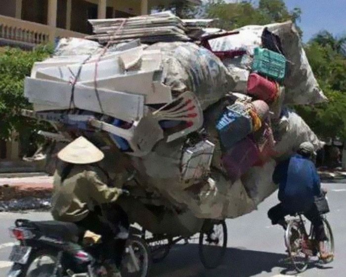 Motorbike overloaded with bags and boxes of belongings, showing an extreme moving fail