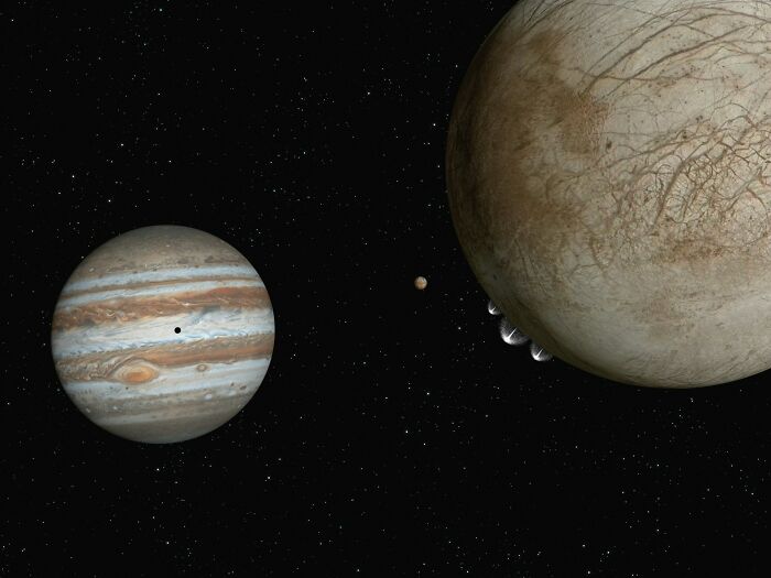 Jupiter and its moon Europa in the dark expanse of space, representing cool facts about the universe.