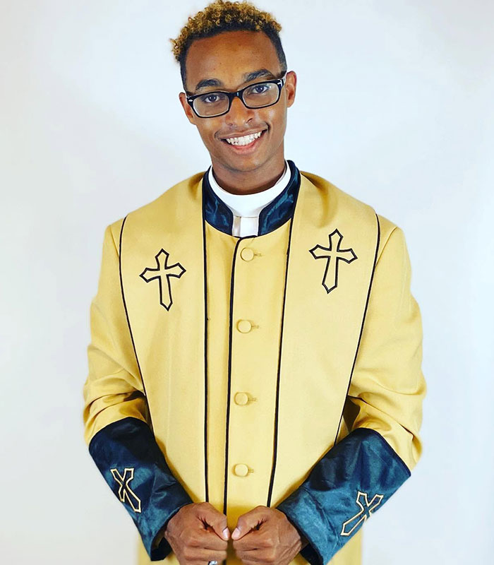 A smiling man in a gold and black clerical robe with cross emblems, illustrating the pastor accused of being a cruise ticket scammer. A smiling man in a gold and black clerical robe with cross emblems, illustrating the pastor accused of being a cruise ticket scammer.