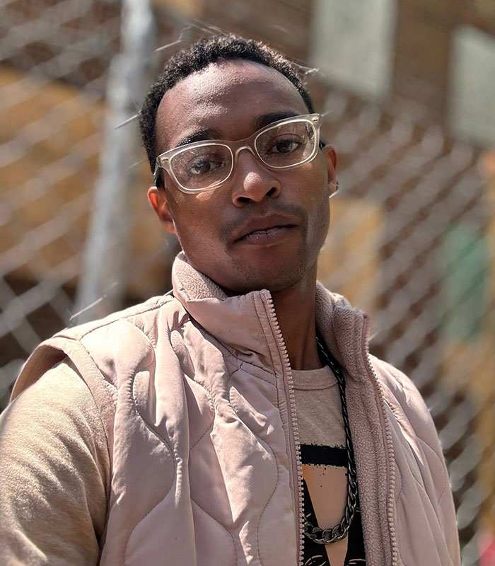 Portrait of Armonte Wilson, the alleged cruise ticket scammer, wearing glasses and a light-colored vest. Portrait of Armonte Wilson, the alleged cruise ticket scammer, wearing glasses and a light-colored vest.