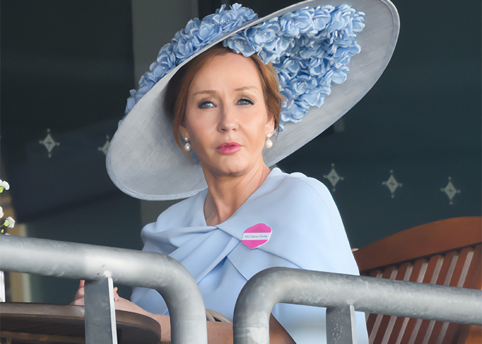 J.K. Rowling in a blue outfit and large floral hat, facing growing Harry Potter backlash and scandal debates. J.K. Rowling in a blue outfit and large floral hat, facing growing Harry Potter backlash and scandal debates.