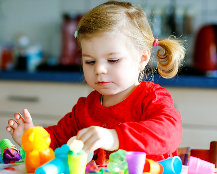 A young child playing with colorful toys, reflecting a child's activity in a nursery setting.