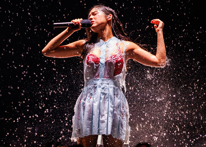 Olivia Rodrigo singing onstage with a melting dress and water droplets during her tour Olivia Rodrigo singing onstage with a melting dress and water droplets during her tour