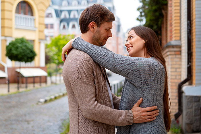 A happy young couple hugging on a street after starting an open relationship. A happy young couple hugging on a street after starting an open relationship.
