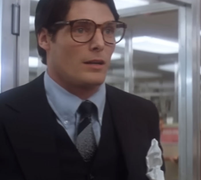 Christopher Reeve in a suit and glasses as Clark Kent, representing classic celebrities and their stories.