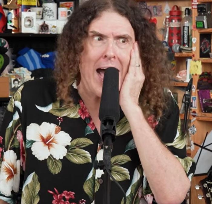 Weird Al Yankovic singing into a microphone, illustrating encounters with celebrities.