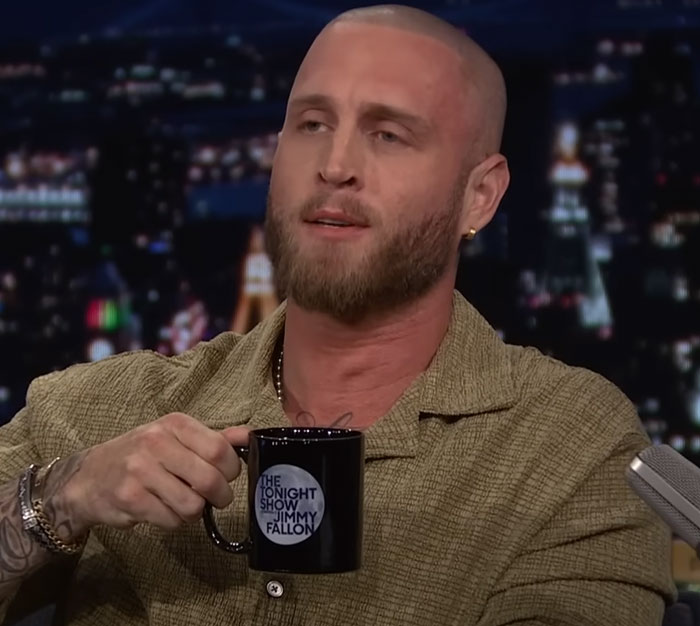 Chet Hanks, one of the modern celebrities, holding a Jimmy Fallon mug on a talk show