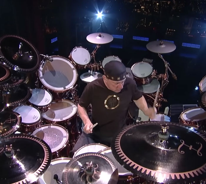 Legendary drummer Neil Peart, among top celebrities, performing a drum solo on a massive kit