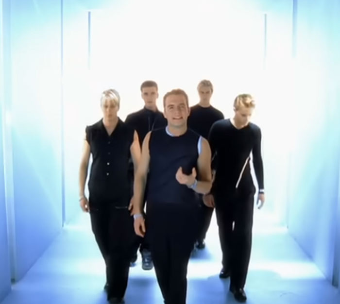 A boy band walking down a hallway, representing celebrities' unexpected visits