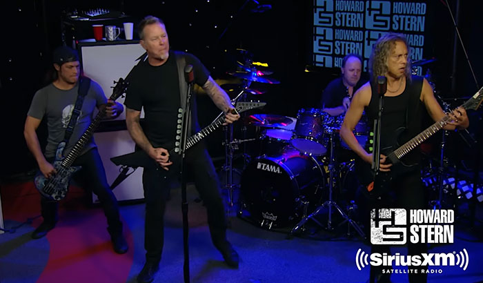 Members of the band Metallica performing live, highlighting stories about celebrities.