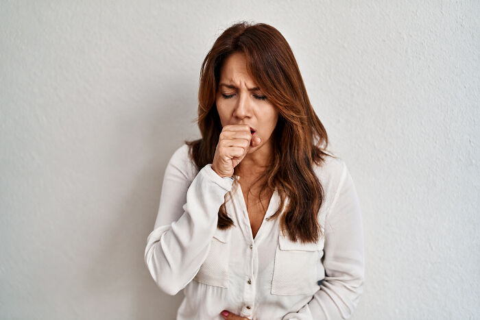 Woman with painful bloating, unable to burp, holding her stomach.