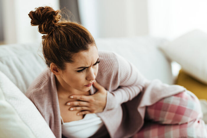 Woman with painful bloating experiencing discomfort in her chest.