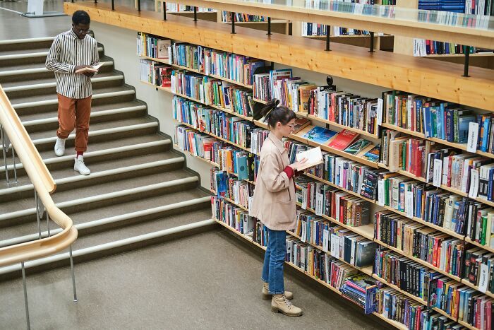 Two people reading in a library, a quiet moment where a 6th sense might detect an issue.