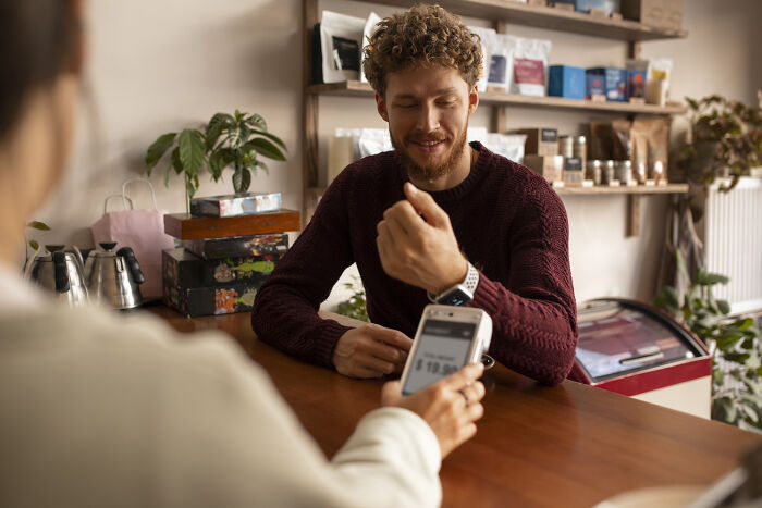 A customer paying with a smart watch, highlighting daily interactions affected by subtle sexism