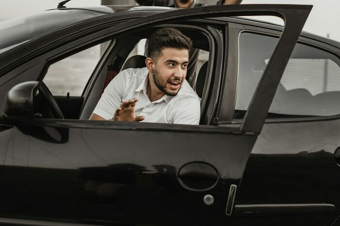 A man looking distressed in a car, depicting savage things people did after relationships fell apart.