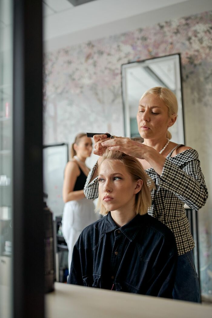 A stylist working on a client's hair, symbolizing transformations after relationships fell apart.