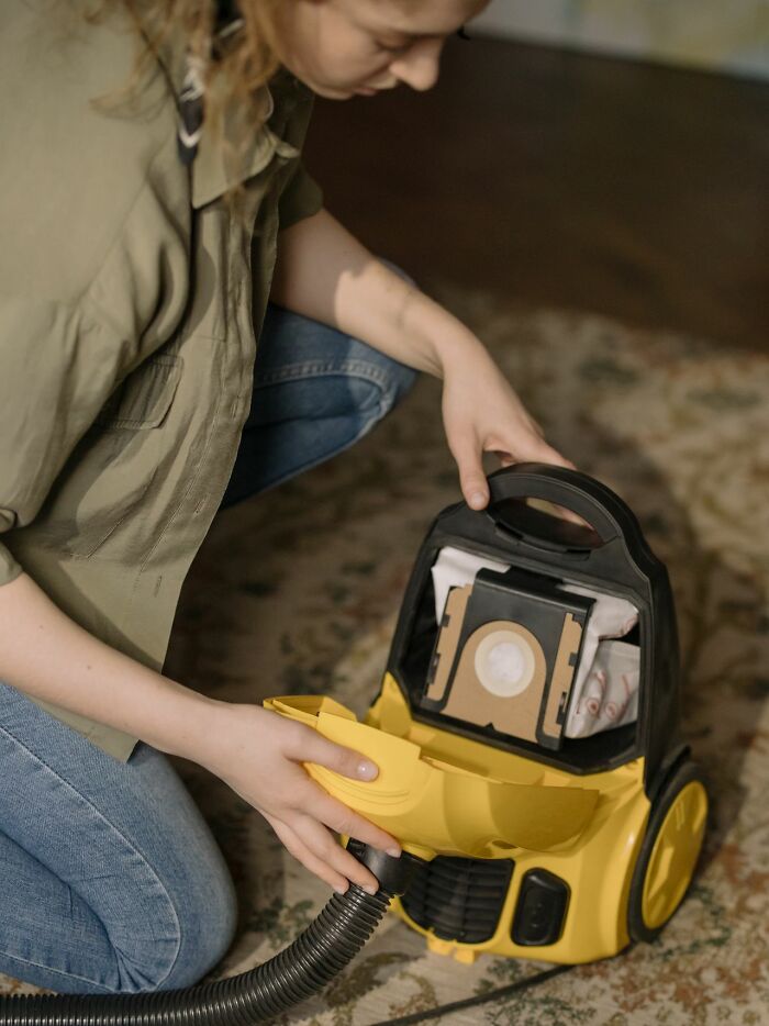 A person changing a vacuum cleaner bag, not related to savage things people did after relationships fell apart.