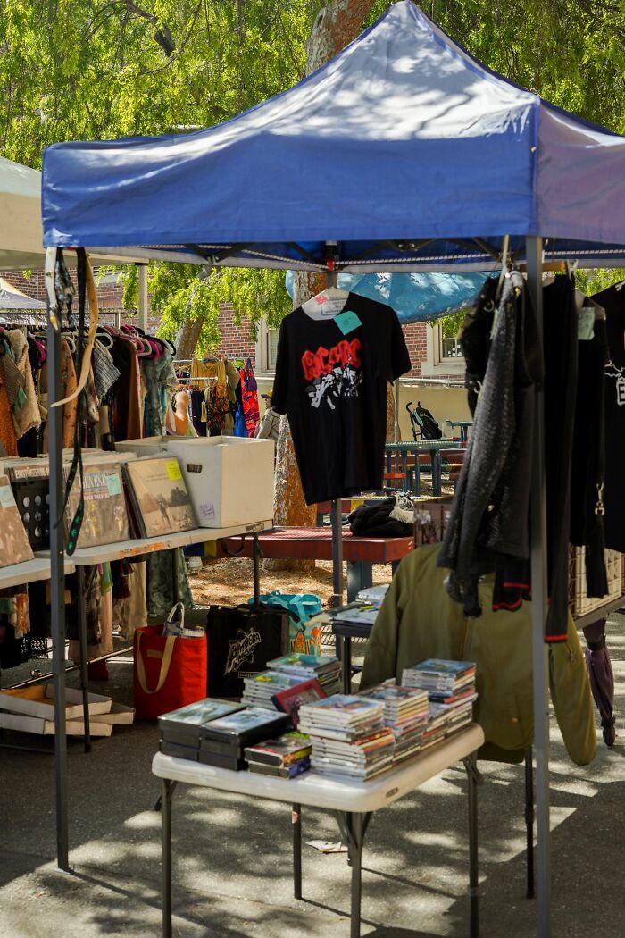 A stall at a market selling clothes and CDs, showing simple joys that are now mainstream.