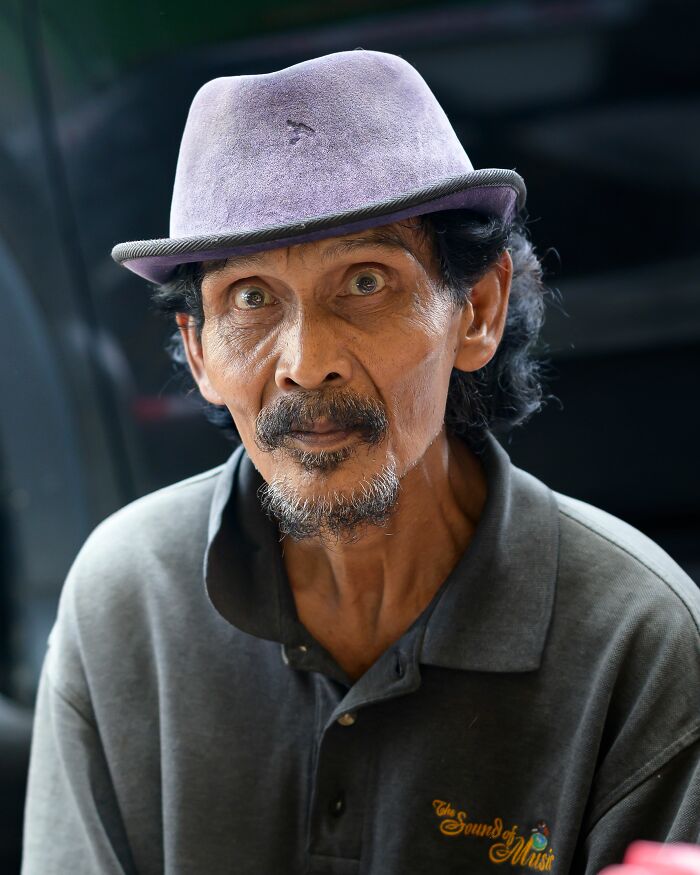 A man in a purple hat with a serious expression, possibly a client seeking help from therapists for complex issues.