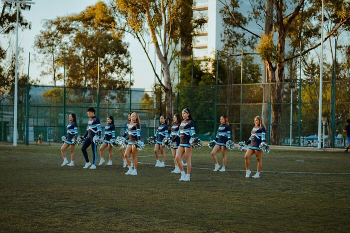 Cheerleaders on a sports field, a popular stereotype about the US.