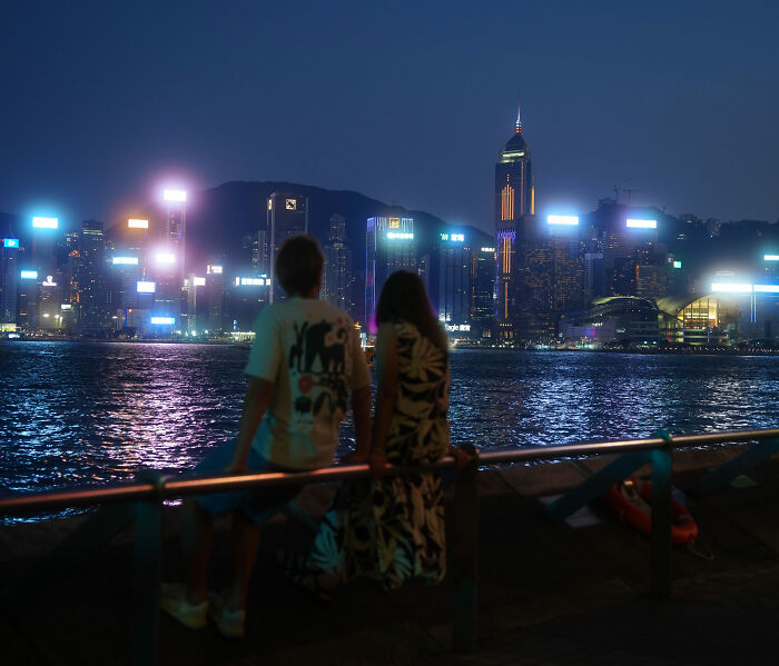 Couple enjoying nighttime cityscape by the water on vacation