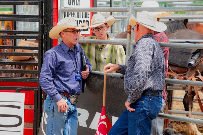 Cowboys wearing hats at a rodeo, a common stereotype about the US.