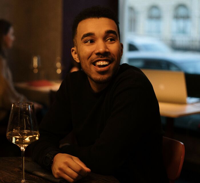 A happy young man smiling at a restaurant, showing how having class is about attitude