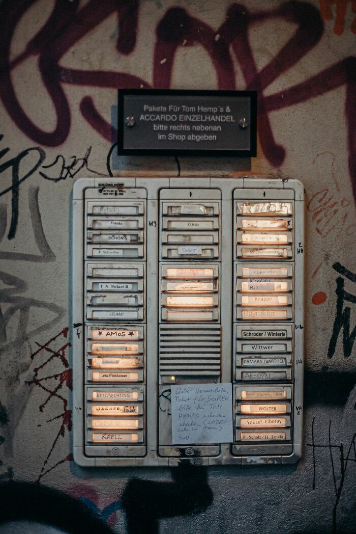 An old intercom system on a graffiti-covered wall, providing safety tips for women living alone to protect themselves.