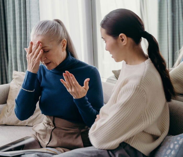 Frustrated older woman upset while younger woman talks about respecting boundaries Frustrated older woman upset while younger woman talks about respecting boundaries