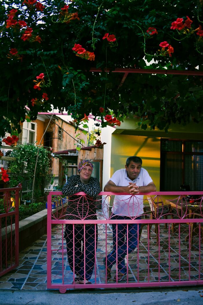 A couple smiling behind a pink fence, offering safety tips for women living alone to protect themselves.