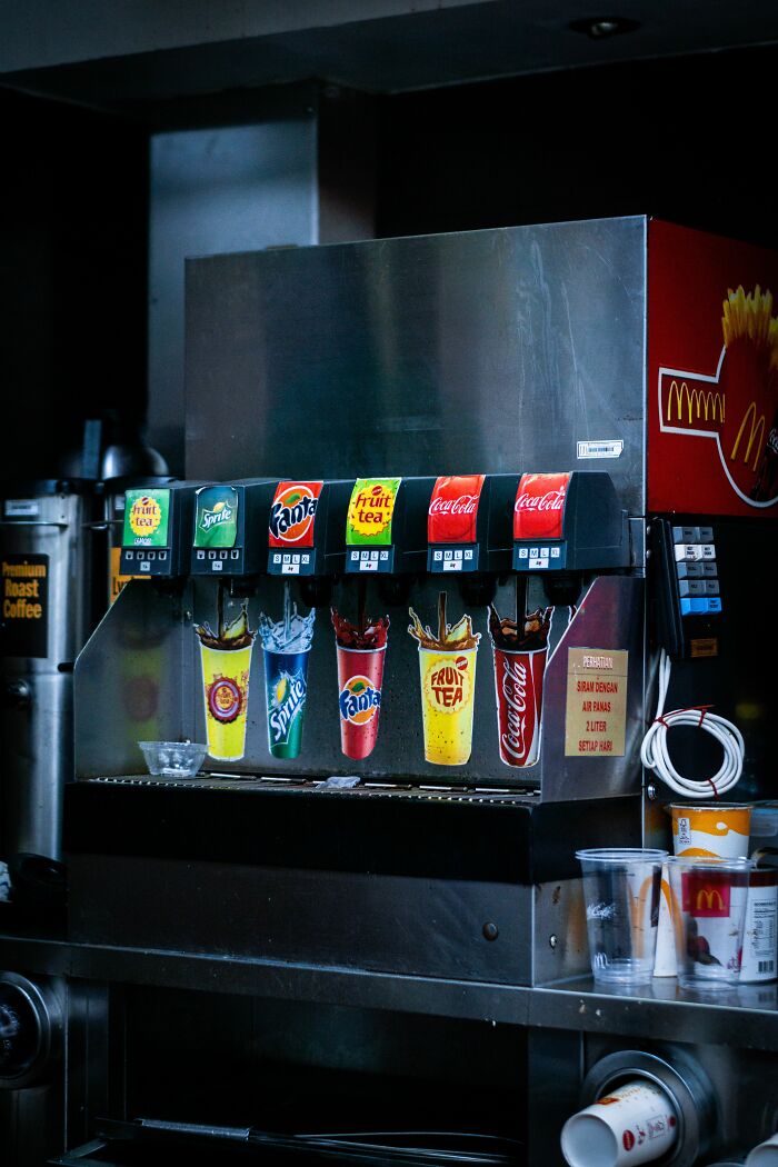 A soda fountain machine with various drink dispensers, hinting at widely known industry secrets in the beverage industry.