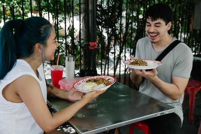 A happy couple enjoying a meal outdoors, reflecting a stereotype about the US.