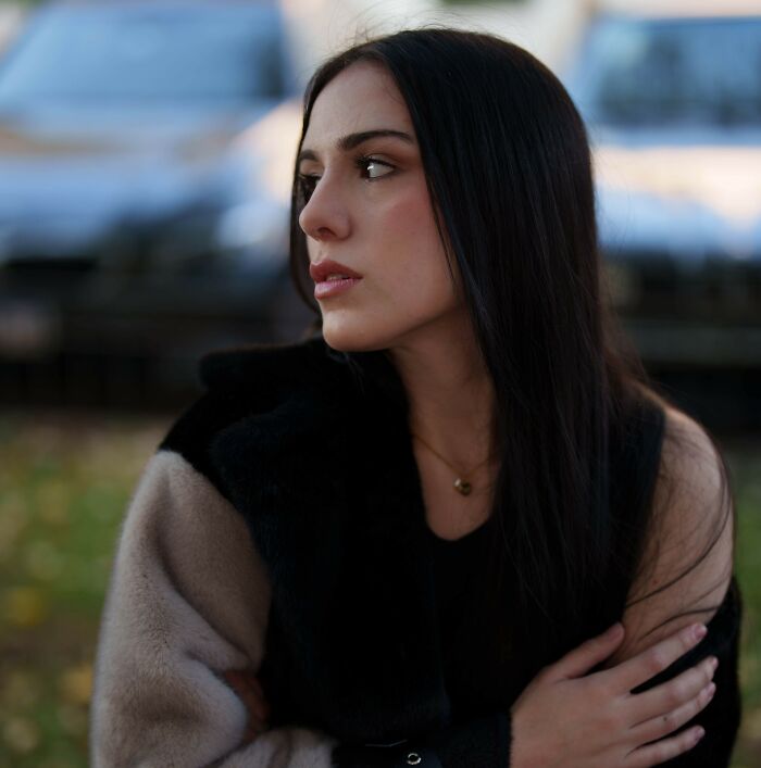 A therapist, looking thoughtful with her arms crossed, considering her experience with a sociopath.