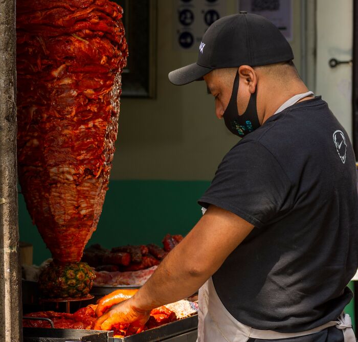 A street vendor slicing meat for tacos, a scenario unrelated to major scandals