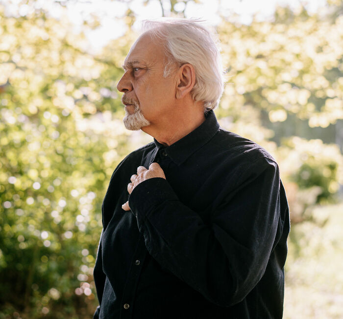 An older man clutching his chest, worried about health symptoms that terrify doctors.