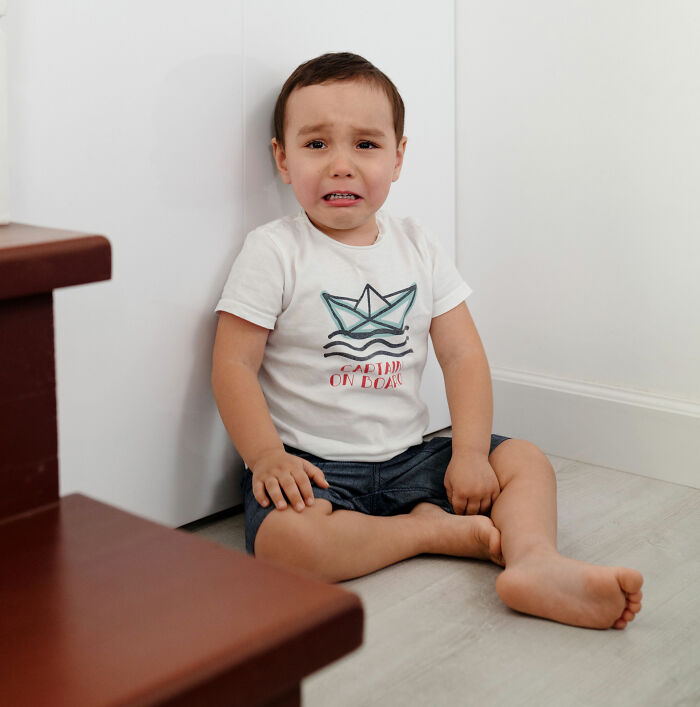 A young child crying on the floor, symbolizing children's feelings parents may not initially comprehend.