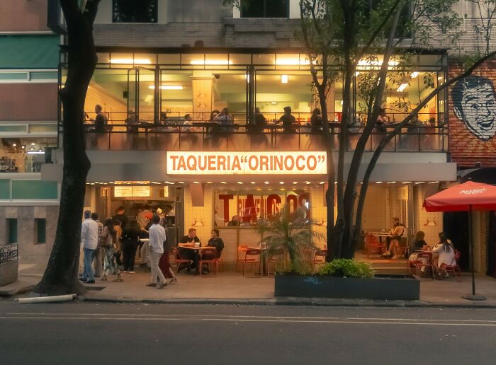 Busy taqueria restaurant with customers dining inside and outside
