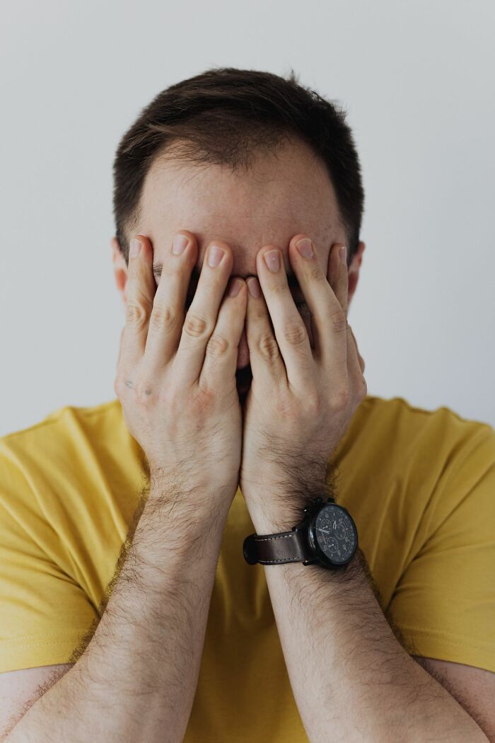 Man covers his face with his hands, feeling distressed before being served delicious dinner.