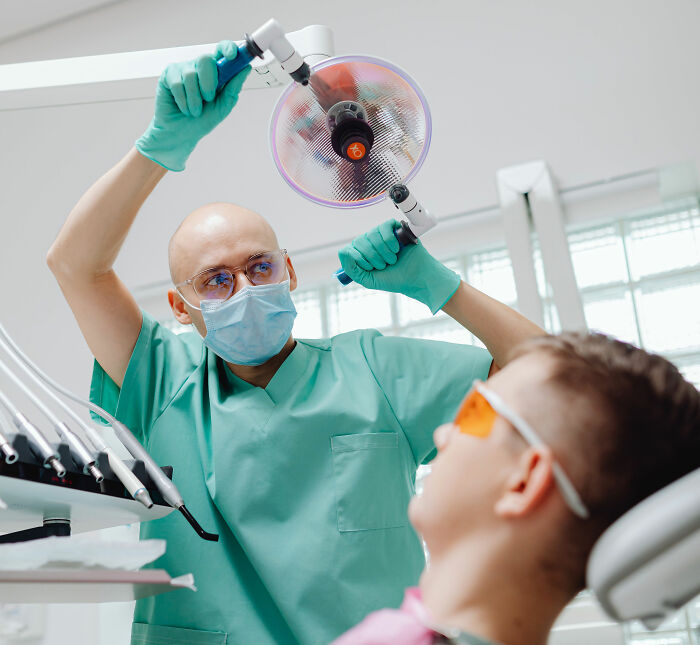 Dentist examining a patient, looking for health symptoms that terrify doctors.