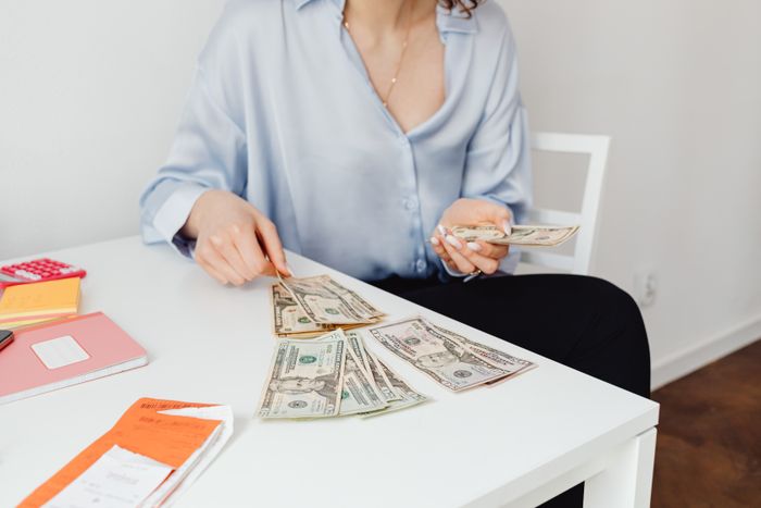 A woman sitting at a desk counting cash from wedding guests A woman sitting at a desk counting cash from wedding guests