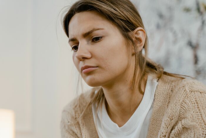 A woman with a concerned expression, wearing a beige cardigan, as a therapist discusses recognizing a sociopath.